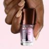hand of a lady holding a bottle of Mineral Fusion Base Coat Nail Polish- Glossy 0.33 oz